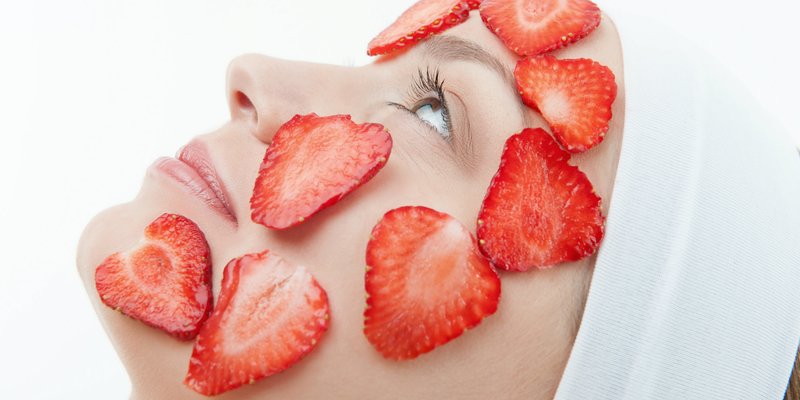 Fille avec un masque de fraise sur son visage