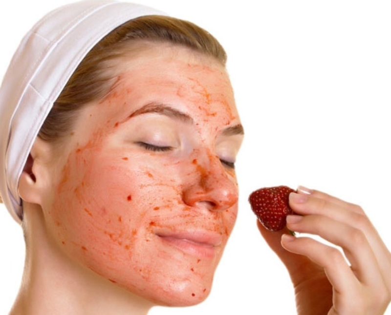 Fille se frotte le visage avec du jus de fraise