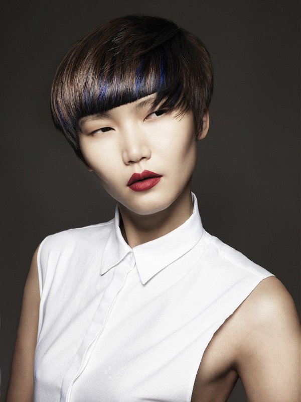 Fille avec un chapeau de coupe de cheveux et une courte frange droite