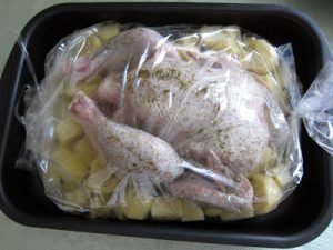 Poulet dans une manche avec des pommes de terre