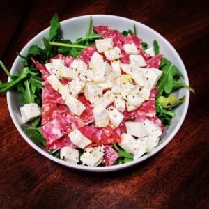 Salade avec saucisse fumée, fromage et roquette