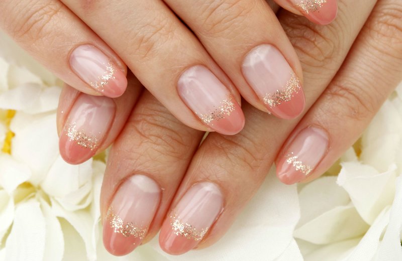 Ongles nude avec veste orange et paillettes d'or