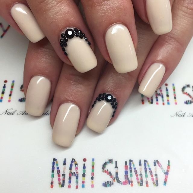 Ongles vernis nude et trous en strass noir