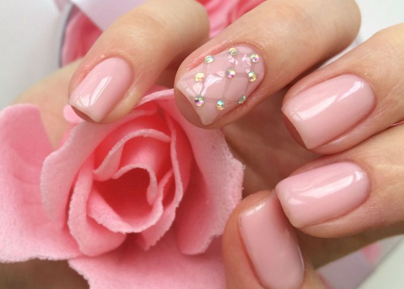 Manucure rose tendance avec des strass.