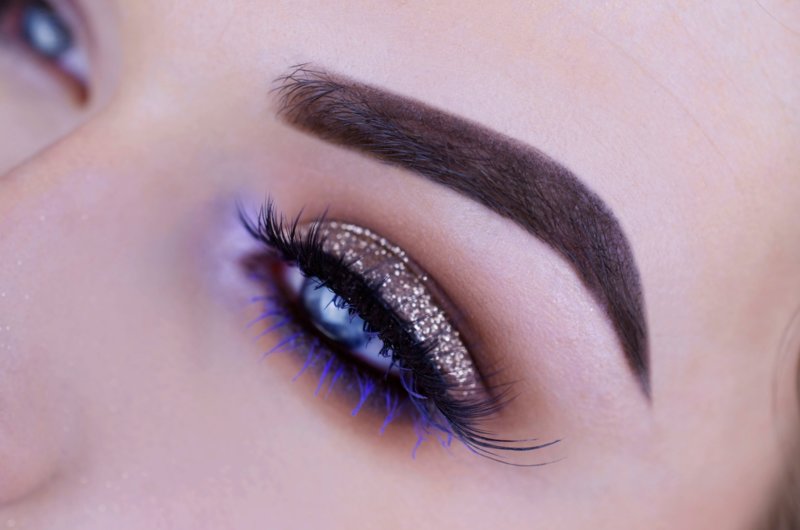 Maquillage doré avec paillettes et mascara violet