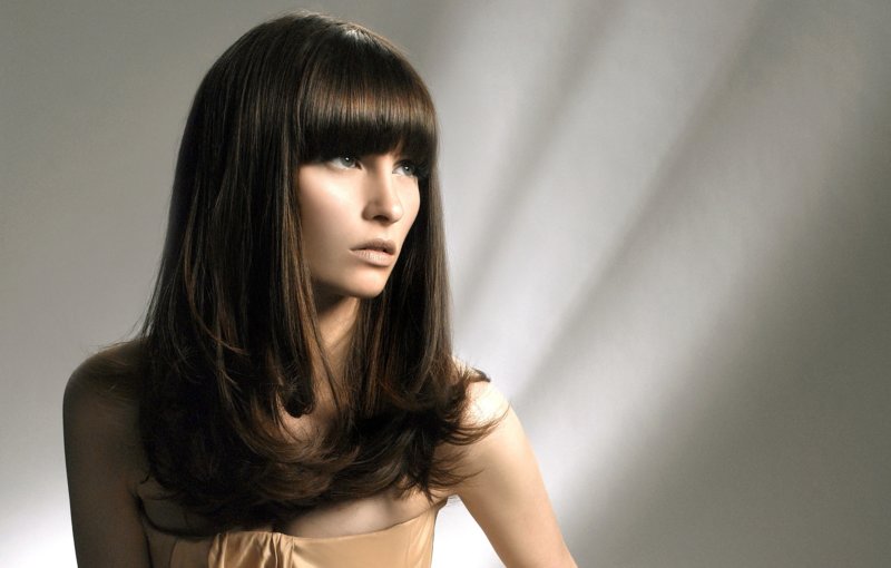 Fille avec une échelle de coupe de cheveux avec une frange droite sur les cheveux longs