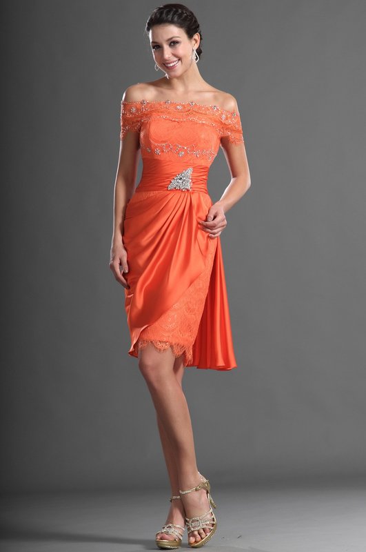 Fille en robe de cocktail orange avec épaules dénudées et strass