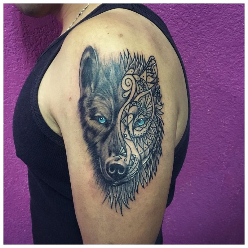 Paghaluin ng mga istilo - isang lobo tattoo sa braso ng isang lalaki