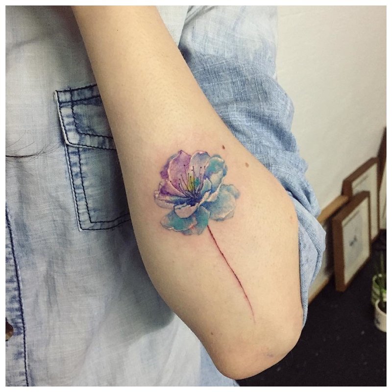 Ang tattoo ng bulaklak ng watercolor sa kamay