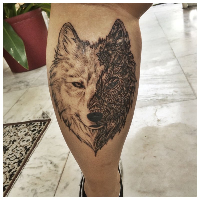 Magagandang tattoo ng lobo sa guya ng isang lalaki