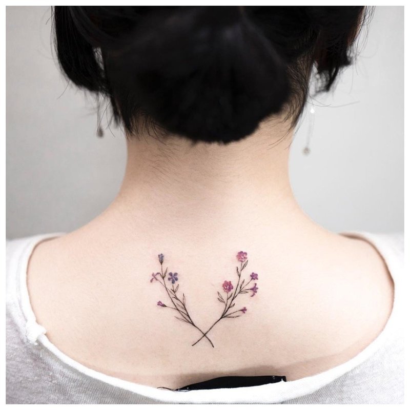 Mga pinong bulaklak - tattoo sa leeg ng batang babae sa likod