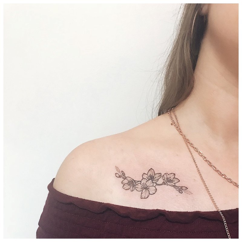 Tatouage de fleur de contour sous la clavicule